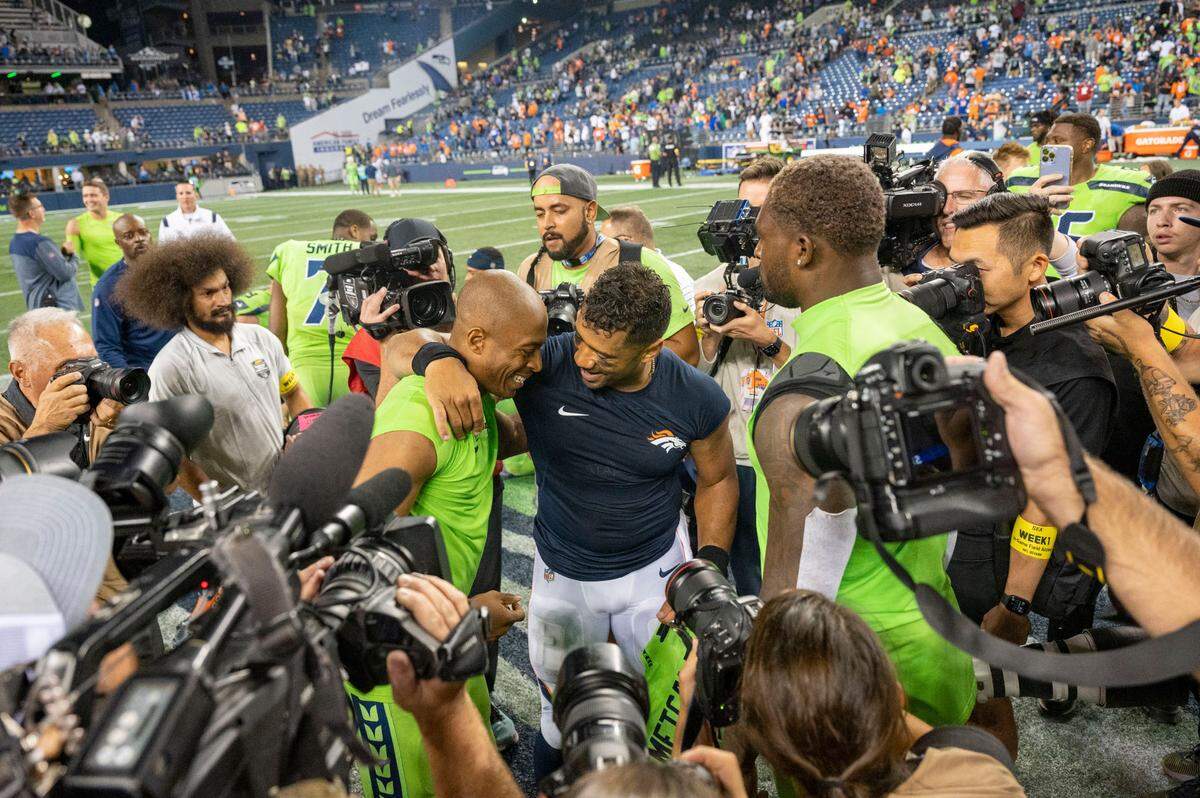 Denver Broncos quarterback Russell Wilson (3) hugs former teammate Seattle Seahawks wide receiver Tyler Lockett (16) after the game on Monday, Sept. 12, 2022, at Lumen Field in Seattle.