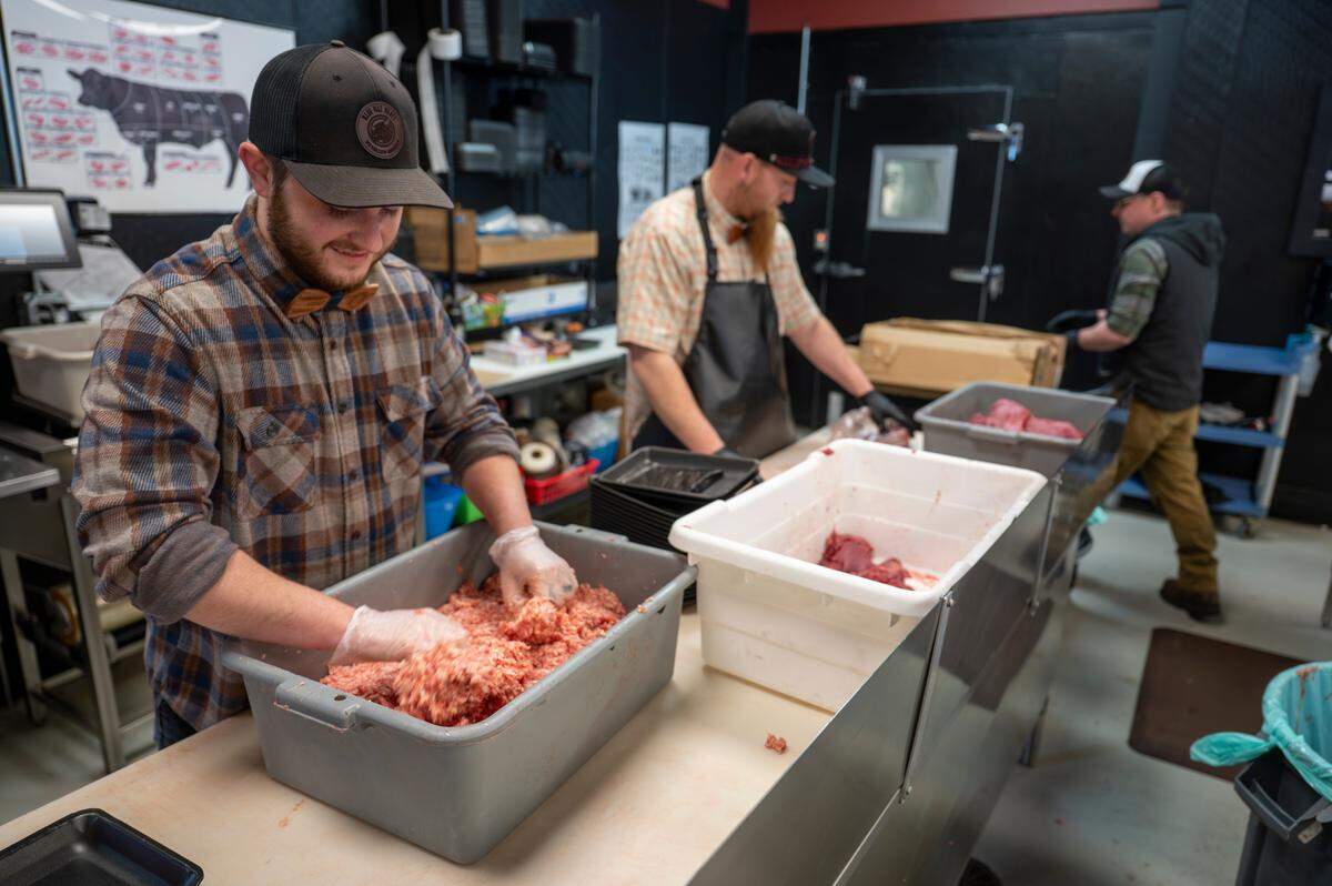 Eli Armstrong, left, works to prepare breakfast sausages before opening at Blue Max Meats in Puyallup on May 21. Staff arrives as early as 5 a.m. to begin cutting, marinating and prepping for the shop’s 11 a.m. open.