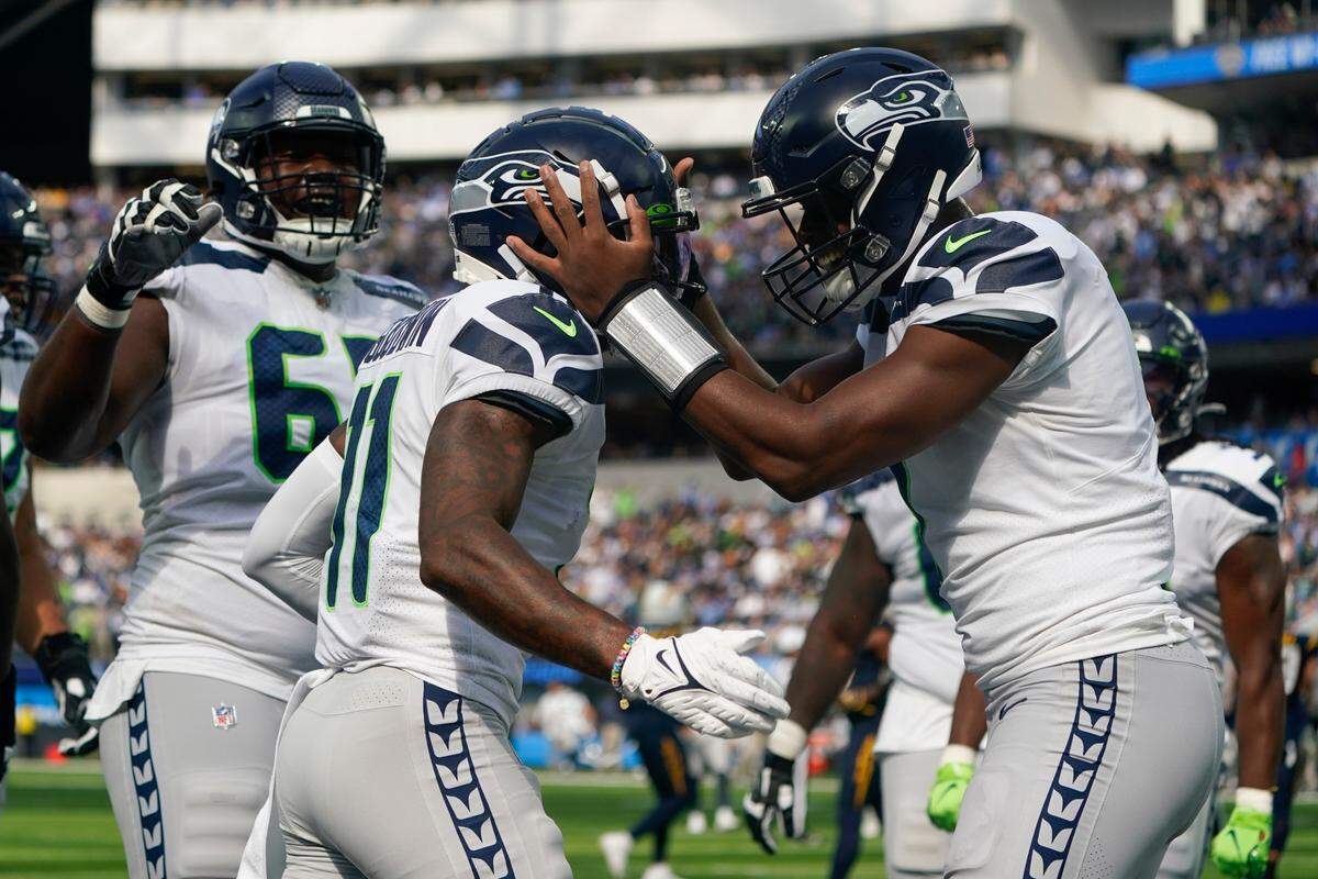 Seattle Seahawks wide receiver Marquise Goodwin (11) celebrates with quarterback Geno Smith, right, after scoring a touchdown during the first half of an NFL football game against the Los Angeles Chargers Sunday, Oct. 23, 2022, in Inglewood, Calif. (AP Photo/Marcio Jose Sanchez)