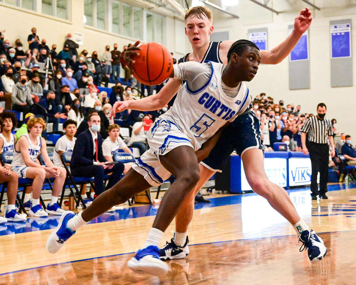 Curtis guard Zoom Diallo (5) drives to the basket as Olympia guard Parker Gerrits (22) defends during the fourth quarter of a 4A South Puget Sound League game on Friday, Jan. 21, 2022, at Curtis High School in University Place, Wash.
