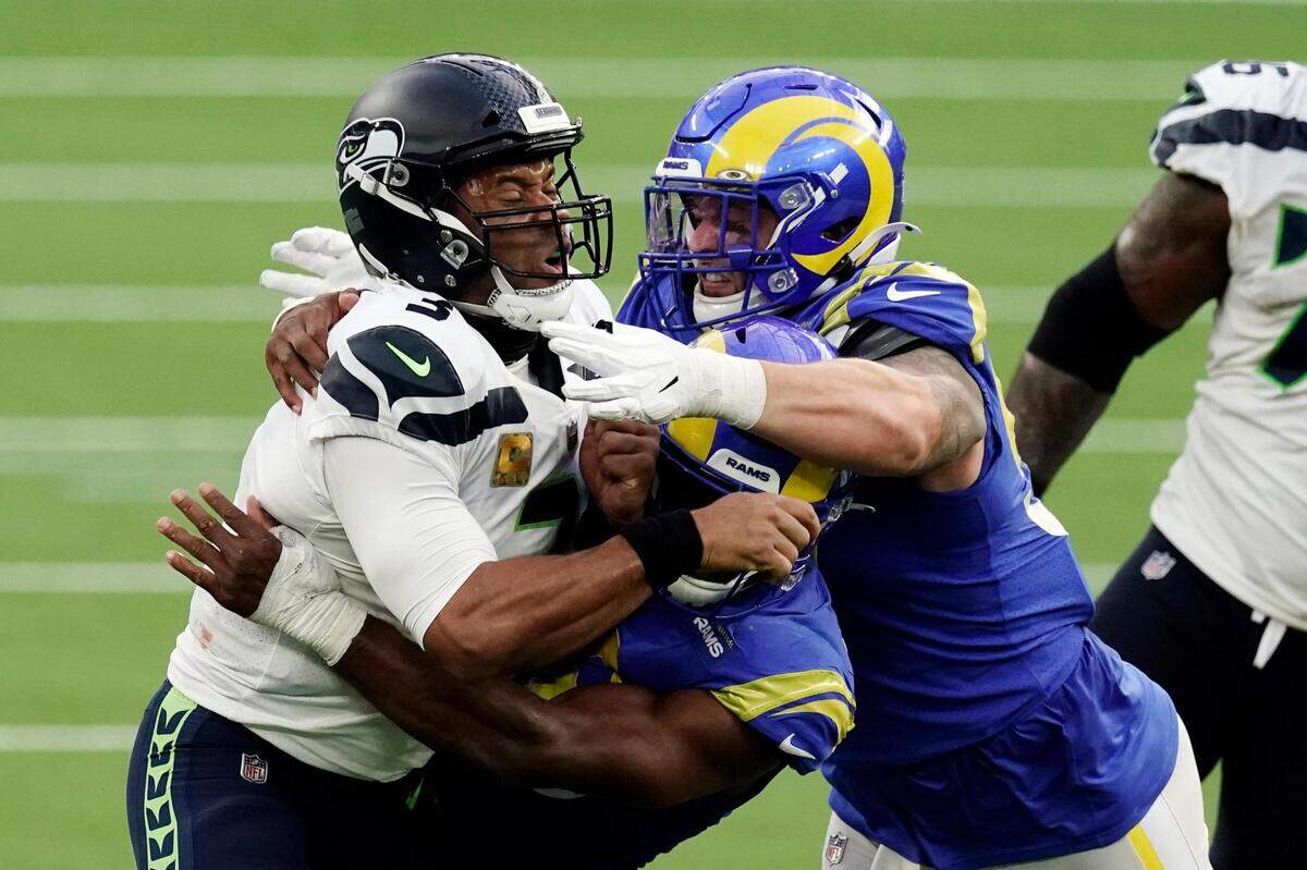 Seattle Seahawks quarterback Russell Wilson (3) is tackled by two against the Los Angeles Rams defenders during the second half of an NFL football game Sunday, Nov. 15, 2020, in Inglewood, Calif. (AP Photo/Jae C. Hong )
