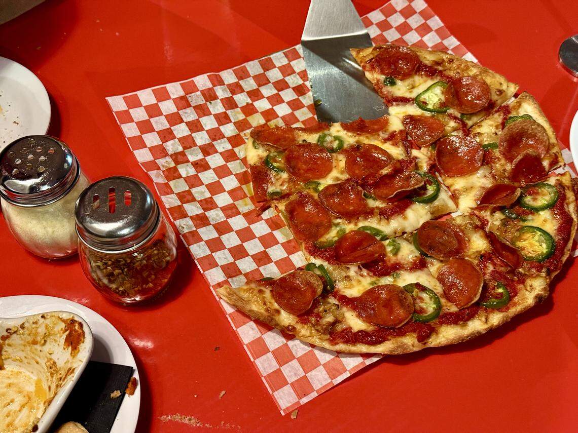 Tacoma Pie has expanded from its initial Detroit-Sicilian-Grandma-style offering to round pies including a pub and tavern, shown here with pepperoni and jalapenos and a devoured plate of manicotti.