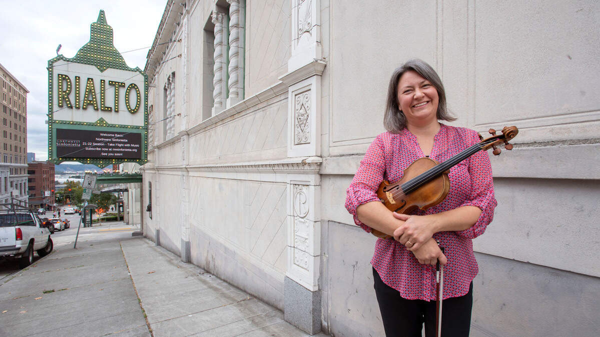 Karin Choo, executive director and violinist for the Northwest Sinfonietta, stands outside the Rialto Theater in Tacoma on Friday, Sept. 10, 2021. People can attend the orchestra’s 2021-22 concert season in-person at that venue beginning Oct. 9 or at the Pioneer Park Pavilion Oct. 10 in Puyallup.