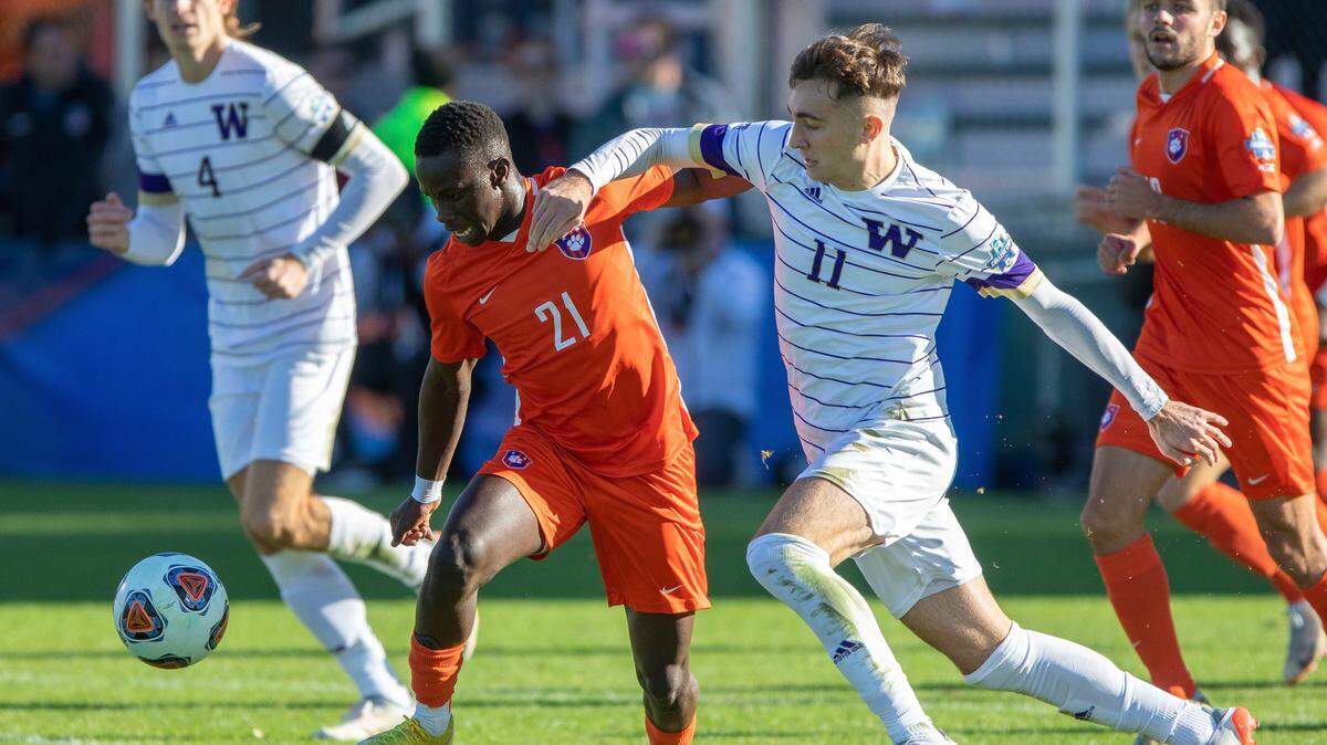 Clemson’s Ousmane Sylla (21) and Washington’s Nick Scardina (11) battle for a ball during the first half of the NCAA college soccer tournament championship in Cary, N.C., Sunday, Dec. 12, 2021. (AP Photo/Ben McKeown)