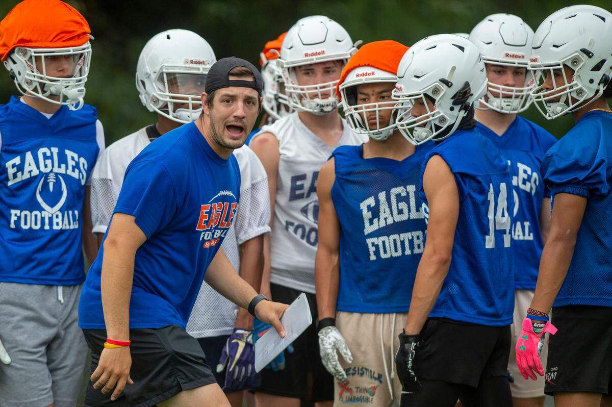 First-year head coach Jeff Logan walks through a drill with the receivers during practice on Thursday, Aug. 18, 2022, at Graham Kapowsin High School, in Graham, Wash.