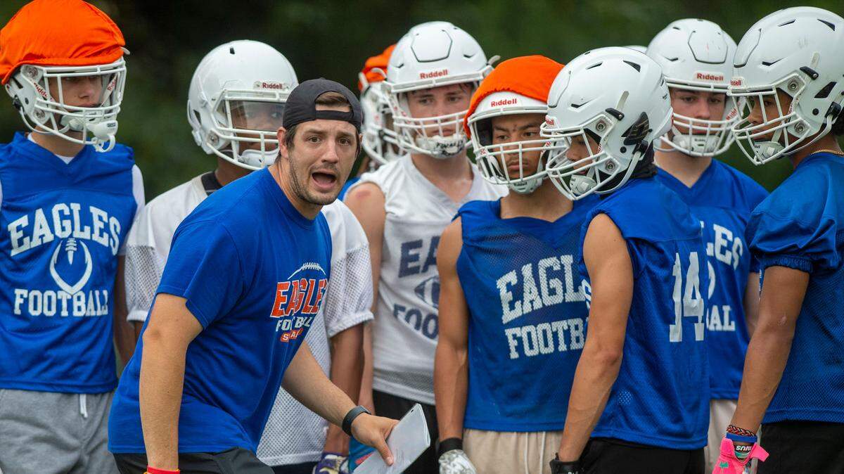 First-year head coach Jeff Logan walks through a drill with the receivers during practice on Thursday, Aug. 18, 2022, at Graham Kapowsin High School, in Graham, Wash.