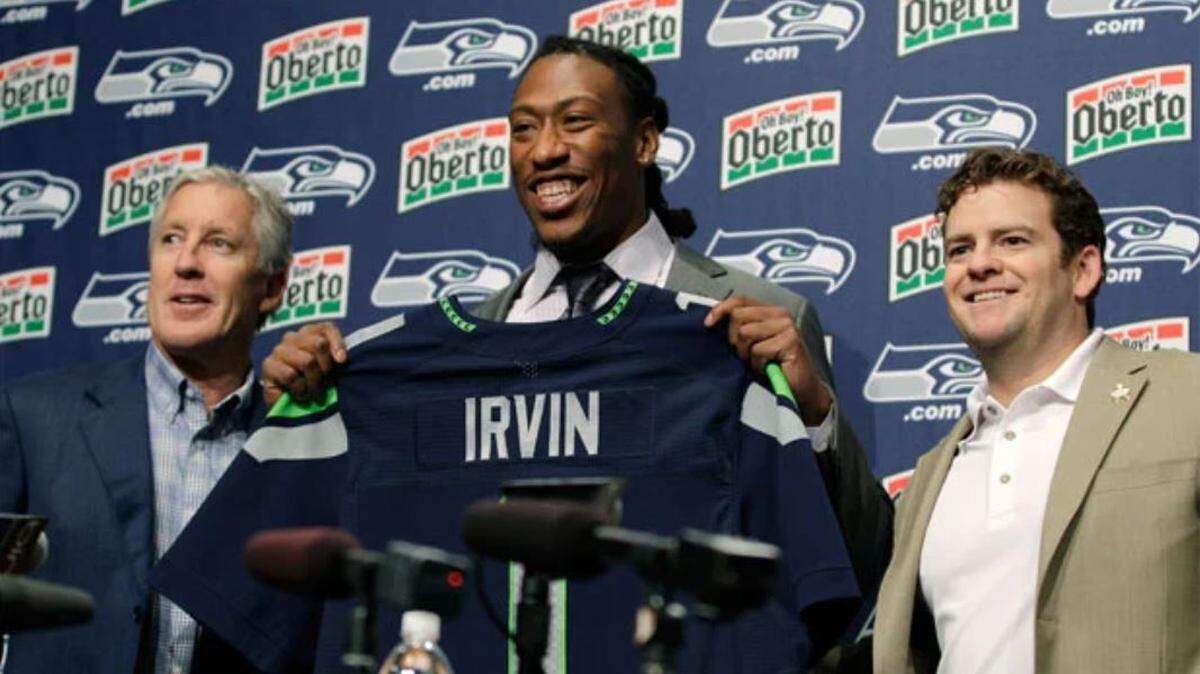 Coach Pete Carroll (left), general manager John Schneider (right) and the Seahawks got roundly criticized for their 2012 NFL draft. That included picking lightly regarded pass rusher Bruce Irvin (center) first, as the 15th-overall pick 10 years ago. Within 22 months, Irvin was a key member of Seattle’s Super Bowl-winning defense.