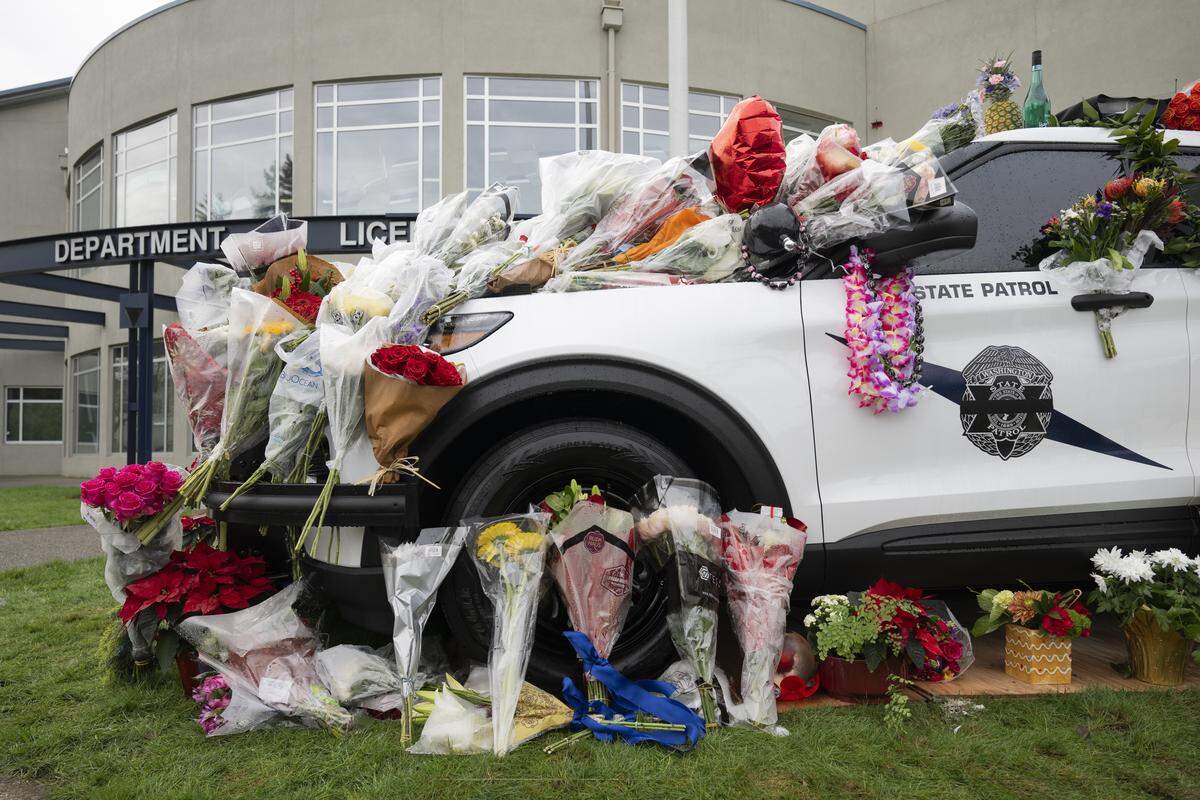 Flowers adorn the patrol car of Tara-Marysa Guting, 29, who was struck and killed by two vehicles Friday night near Port of Tacoma Road, during a memorial at the Washington State Patrol’s District One building on Tuesday, Dec. 23, 2025 in Tacoma, Wash.