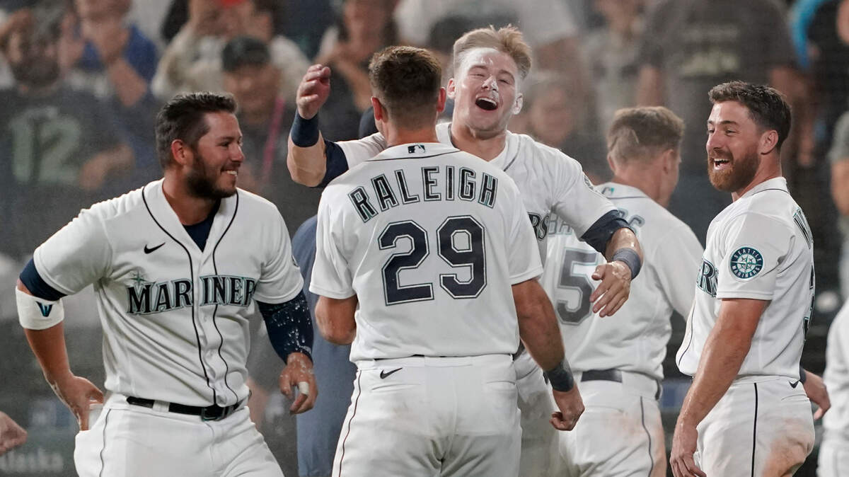 Seattle Mariners’ Jarred Kelenic, center, hugs Cal Raleigh (29) after being covered with powder by teammates after Kelenic scored the winning run on a wild pitch during the ninth inning of the team’s baseball game against the Oakland Athletics, Saturday, July 24, 2021, in Seattle. The Mariners won 5-4. (AP Photo/Ted S. Warren)