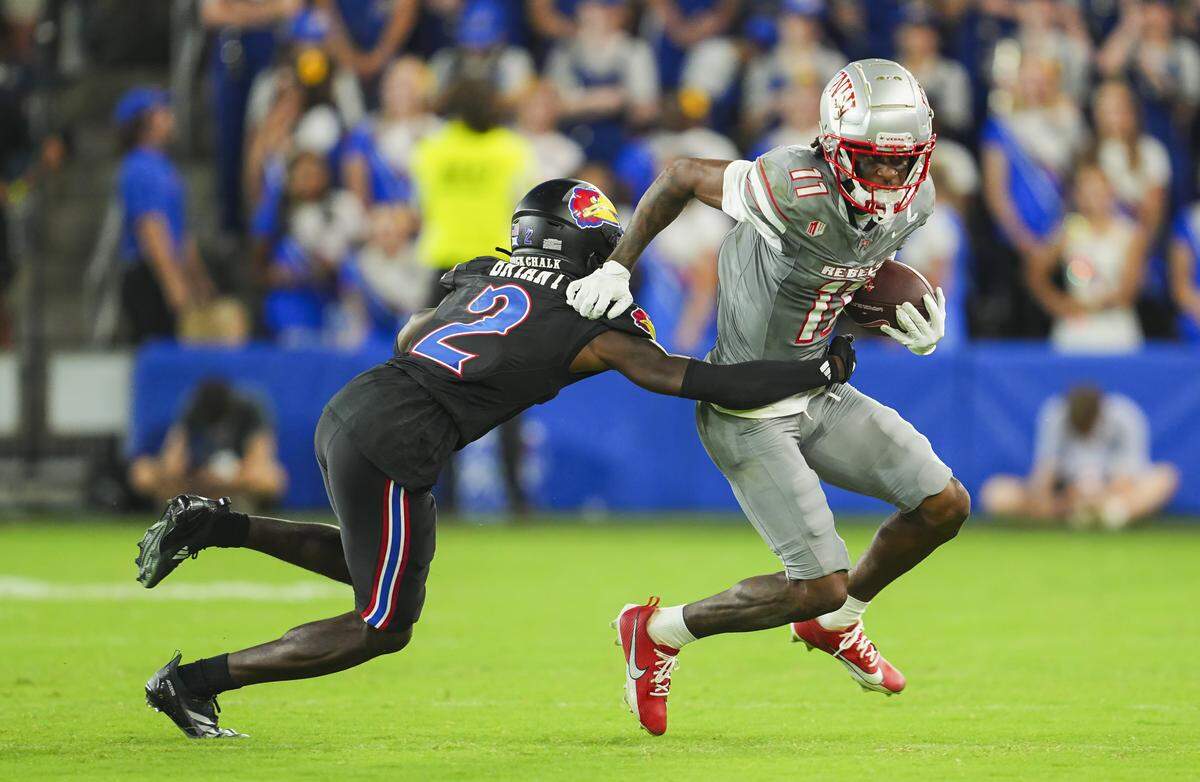 Sep 13, 2024; Kansas City, Kansas, USA; UNLV Rebels wide receiver Ricky White III (11) runs with the ball against Kansas Jayhawks cornerback Cobee Bryant (2) during the second half at Children's Mercy Park. Mandatory Credit: Jay Biggerstaff-Imagn Images