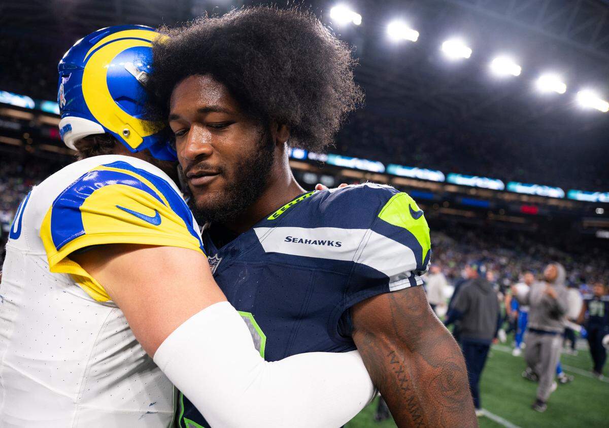 Former teammate Los Angeles Rams quarterback Matthew Stafford (9) and Seattle Seahawks linebacker Ernest Jones IV (13) hug after the Los Angeles Rams 26-20 overtime victory at Lumen Field, on Sunday, Nov. 3, 2024 in Seattle, Wash.