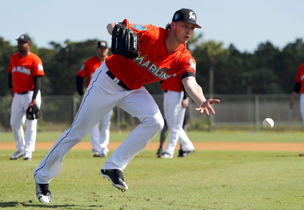Miami Marlins pitcher Adam Conley tosses the ball home during a drill at spring training baseball practice Sunday, Feb. 18, 2018, in Jupiter, Fla. (AP Photo/Jeff Roberson)
