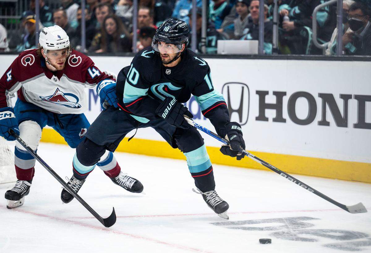 Seattle Kraken center Matty Beniers (10) looks to pass the puck as Colorado Avalanche defenseman Bowen Byram (4) defends during the third period of a first round 2023 Stanley Cup Playoffs game against the Colorado Avalanches at Climate Pledge Arena in Seattle on Saturday, April 22, 2023. The Seattle Kraken lost 4-6 to the Colorado Avalanches.