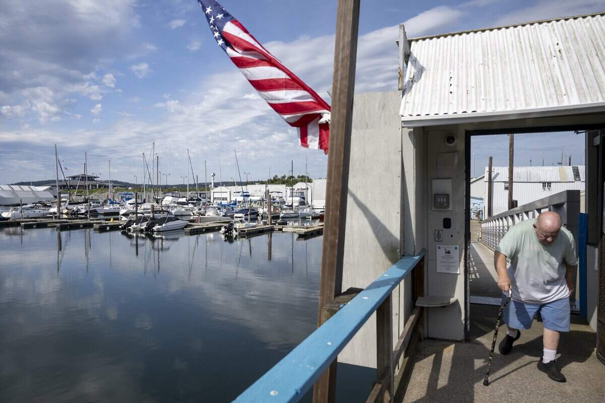 Toni Froehling walks up the ramp to exit Breakwater Marina on Tuesday, May 12, 2026, in Tacoma, Wash. Froehling has a boat house stationed at the Marina.