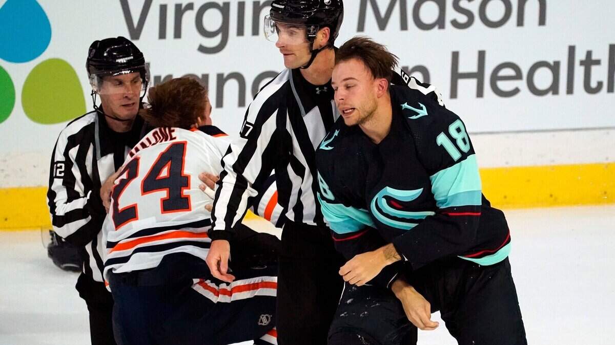 Seattle Kraken’s Carsen Twarysnki (18) is escorted off the ice as Edmonton Oilers’ Brad Malone (24) is assisted up after the two fought in the first period of a preseason NHL hockey Friday, Oct. 1, 2021, in Everett, Wash. (AP Photo/Elaine Thompson)