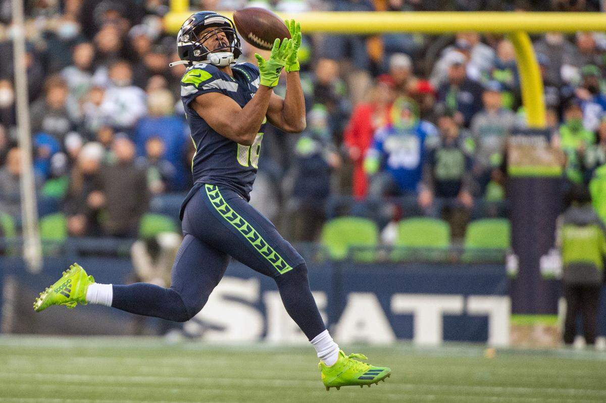 Seattle Seahawks wide receiver Tyler Lockett (16) catches a pass down field from quarterback Russell Wilson (3) during the fourth quarter of an NFL game on Sunday afternoon at Lumen Field in Seattle.