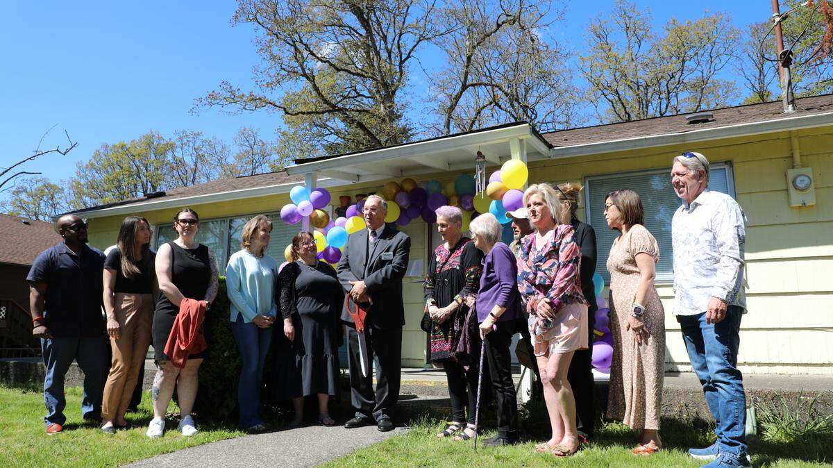 Bethel School District Superintendent, Tom Siegel, stands with the founders and board members of Family Promise of Pierce County as he gets ready to cut the ribbon on their new emergency family shelter.
