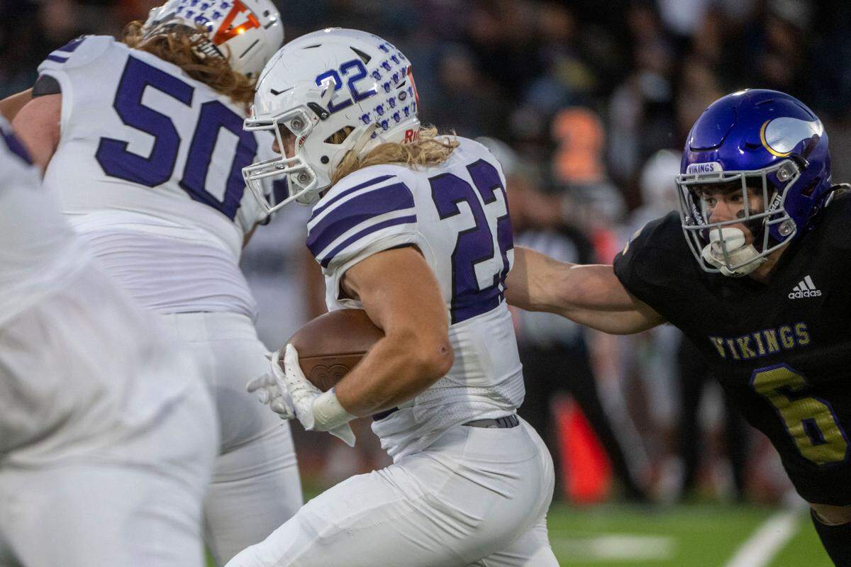 Sumner running back Matthew Spurbeck breaks through a tackle attempt by Puyallup’s Wyatt Gordon during the first quarter of a 4A SPSL game on Friday, Sept. 23, 2022, at Sparks Stadium in Puyallup, Wash.