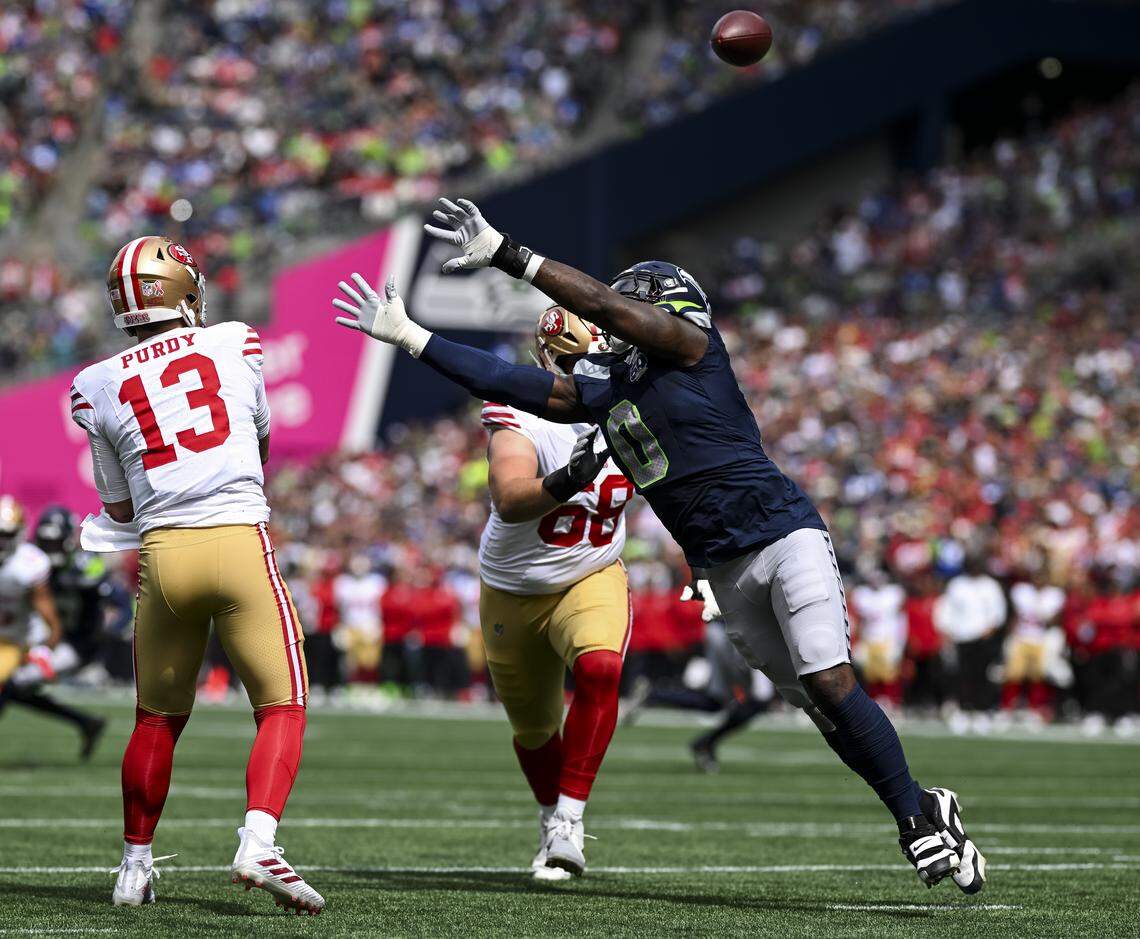 Seattle Seahawks defensive end DeMarcus Lawrence (0) pressures San Francisco 49ers quarterback Brock Purdy (13) during the first quarter of the game at Lumen Field, on Sunday, Sept. 7, 2025, in Seattle.
