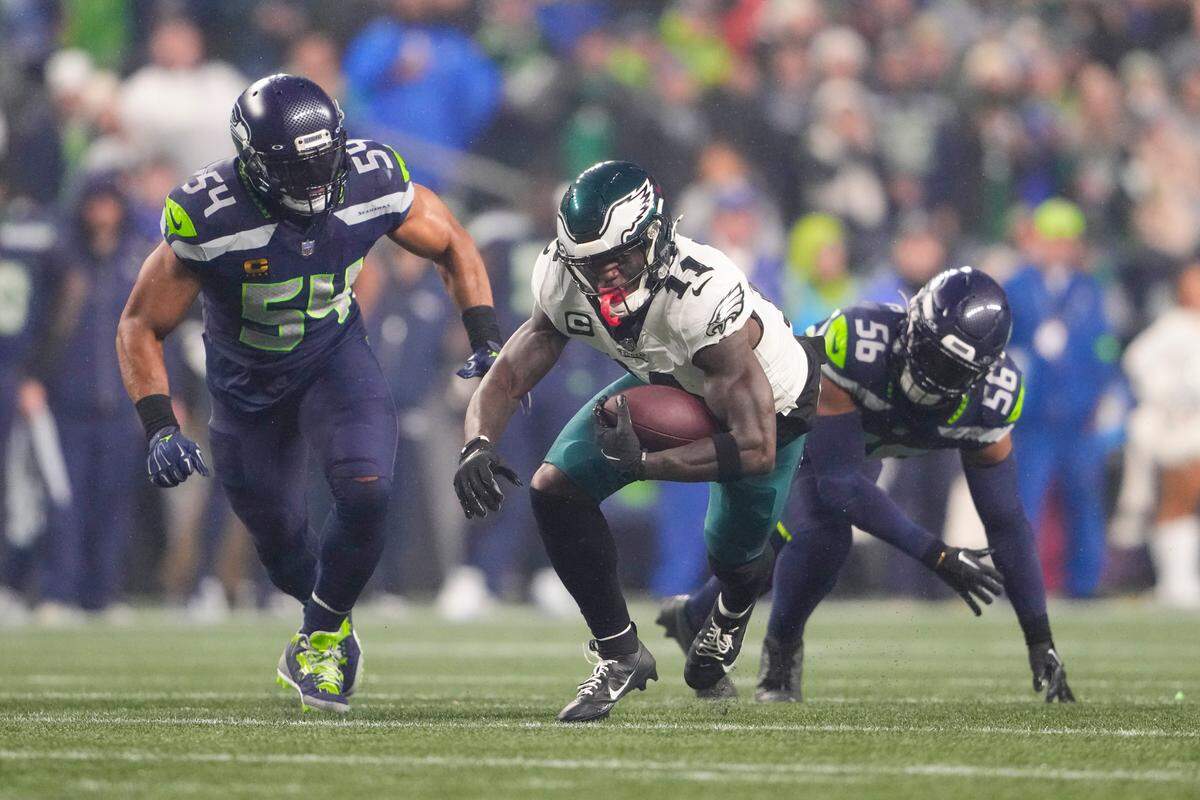 Philadelphia Eagles wide receiver A.J. Brown (11) runs with the ball after making a catch against linebacker Bobby Wagner (54) and linebacker Jordyn Brooks (56) during the first half of an NFL football game, Monday, Dec. 18, 2023, in Seattle. (AP Photo/Lindsey Wasson)