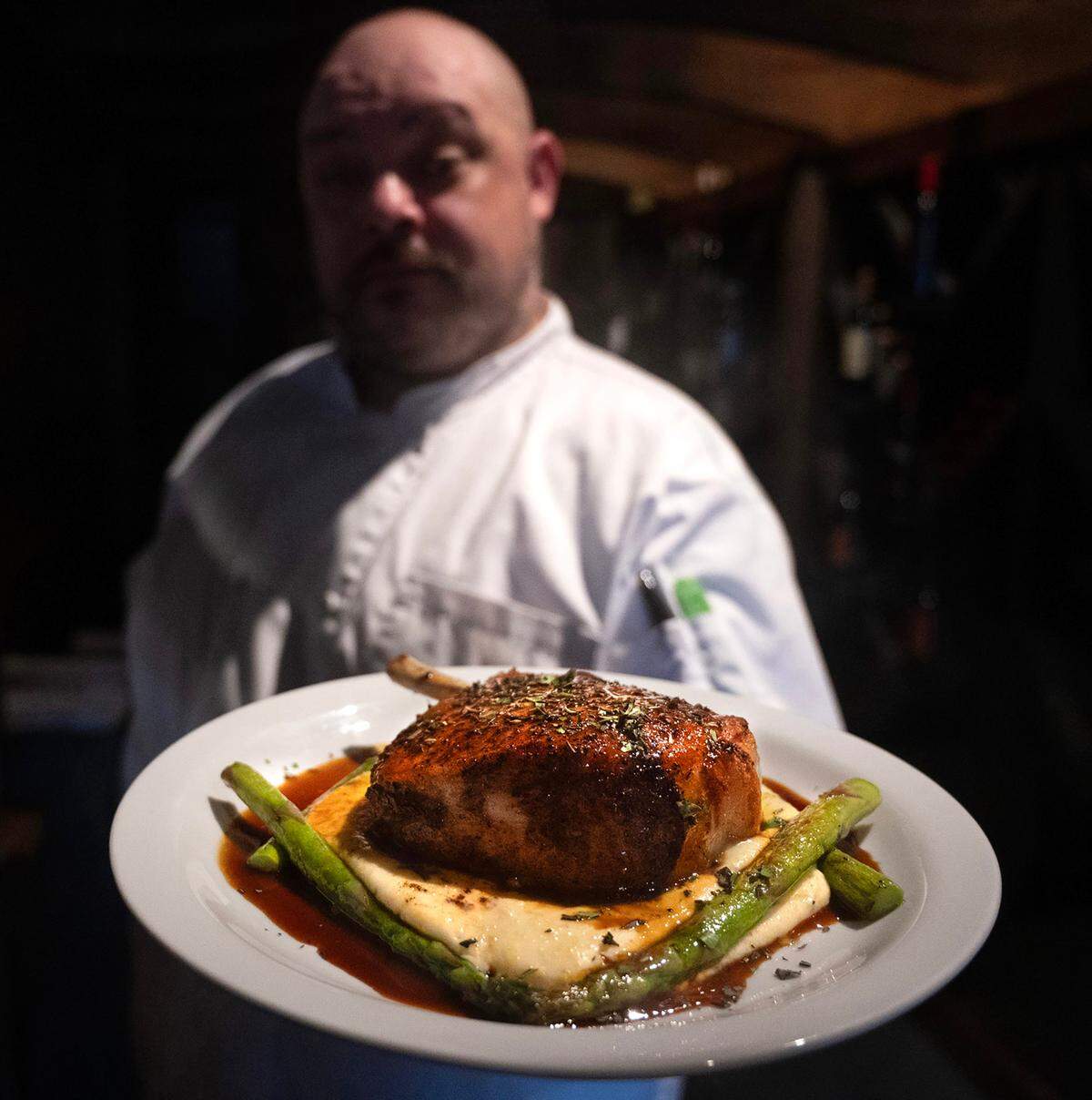 Executive chef Keno Buttner with the Duroc pork chop on creamy polenta with apple cider reduction and asparagus in April 2024. TNT Diner described West 122 as one of the city’s most underrated, with excellent cocktails, strong hospitality and comforting food made with classic techniques and fresh ingredients.