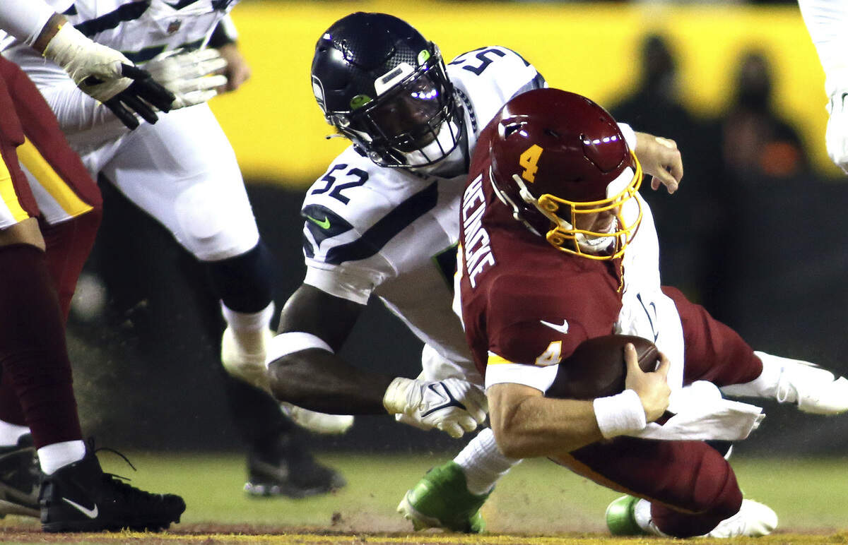 Seattle Seahawks defensive end Darrell Taylor (52) takes down Washington Football Team quarterback Taylor Heinicke (4) during an NFL football game, Monday, Nov. 29, 2021 in Landover. (AP Photo/Daniel Kucin Jr.)