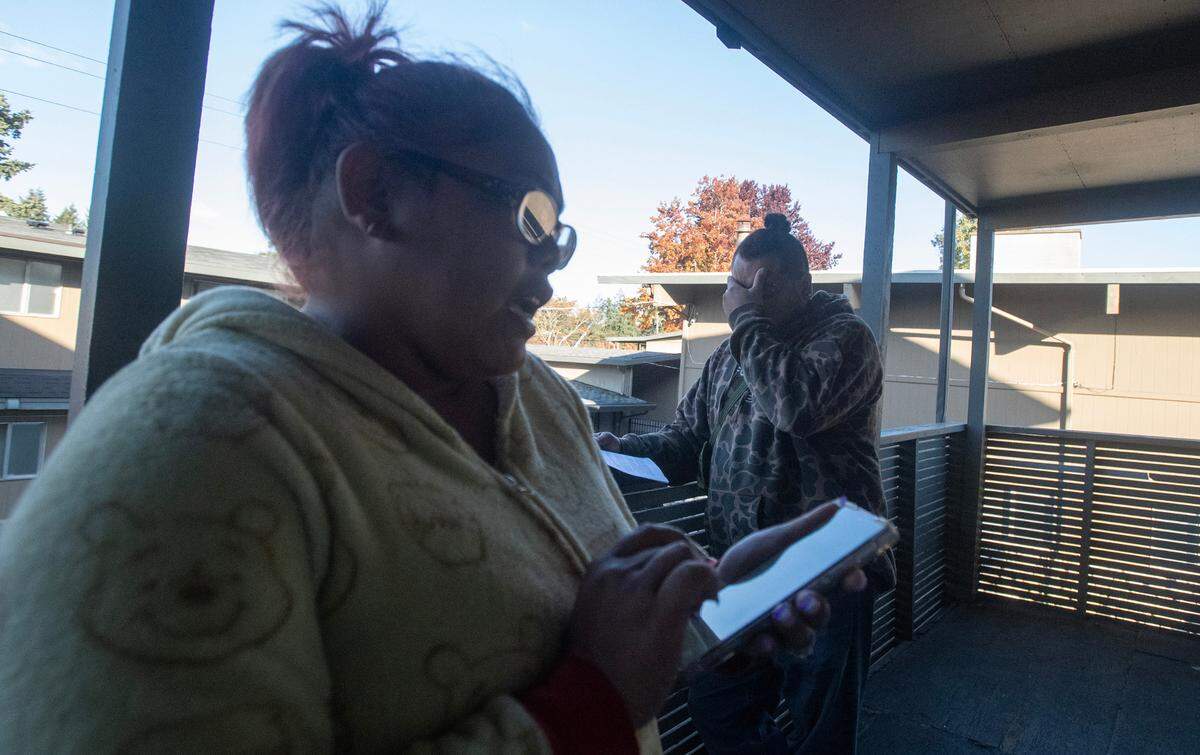 KayleenRose Babauta reads an email from apartment management while her husband, Nathan, reads the 30-day eviction notice at the Legacy Park Apartments in Lakewood, Washington, on Wednesday, Nov. 8, 2023.