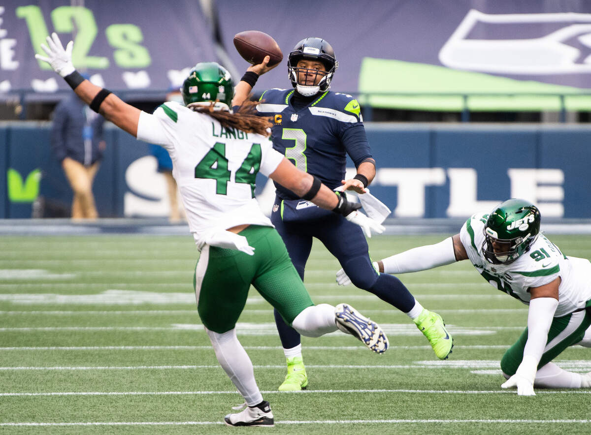 Seattle Seahawks quarterback Russell Wilson throws a pass under pressure during the second quarter. The Seattle Seahawks played the New York Jets in a NFL football game at Lumen Field in Seattle, Wash., on Sunday, Dec. 13, 2020.