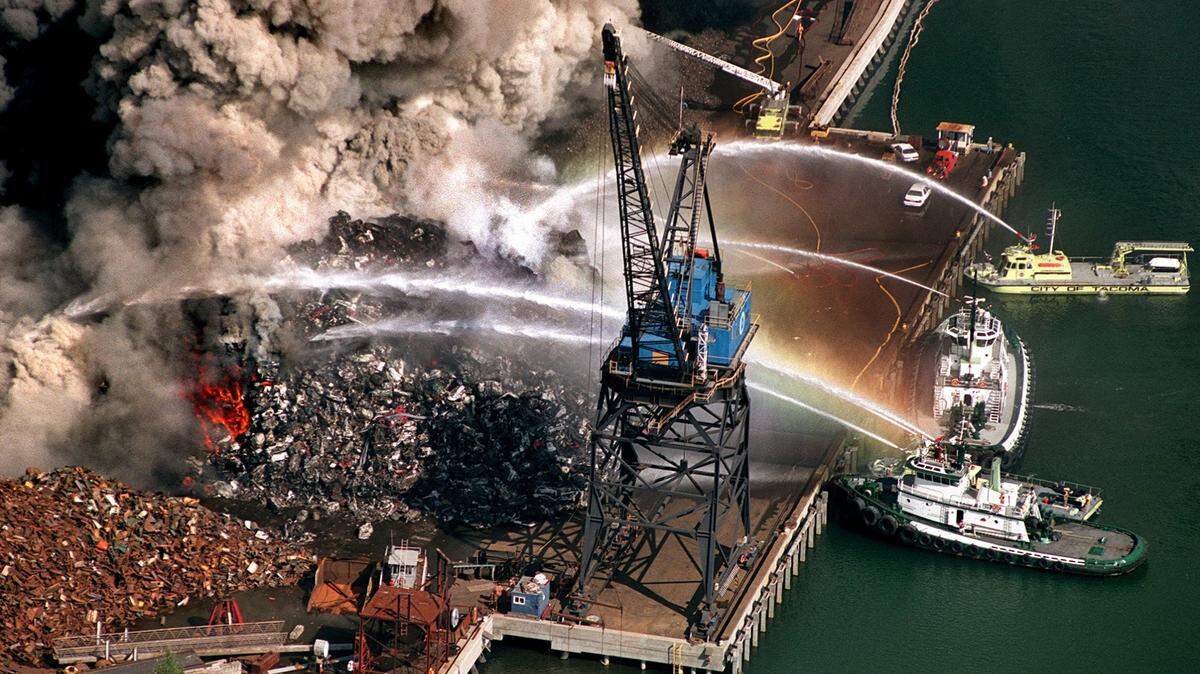 This is an aerial view of the Schnitzer Steel Industries Recycling Center fire on Thursday, July 19, 2001 on the Hylebos Waterway in the Port of Tacoma. Foss tugs and Tacoma fireboats douse the pile of scrap automobiles.