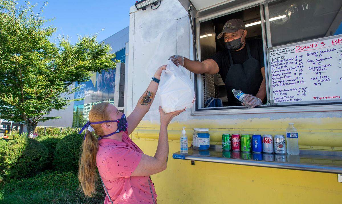 Dowd’s BBQ owner Martin Dowd hands an order of catfish and fries to a customer from his food truck parked outside of the Tacoma Art Museum cafe on Thursday, Sept. 16, 2021. In conjunction with the Kinsey African American Art & History Collection currently on display, a rotation of Black-owned food businesses have been invited to participate in a TAM Cafe Takeover! every Thursday afternoon.