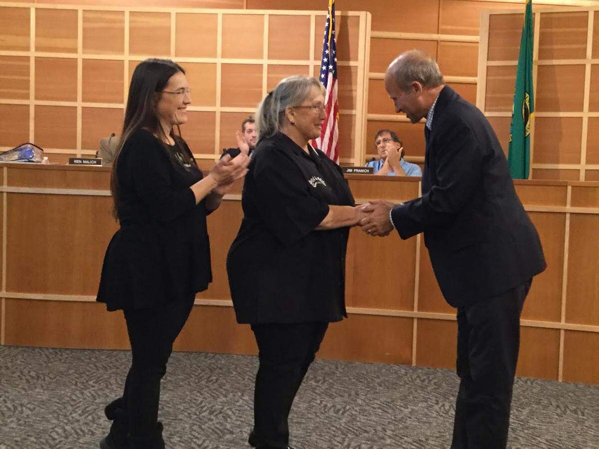 Gig Harbor Mayor Kit Kuhn, right, presents a certificate of proclamation stating United by Music is an artistic asset to the city. The certificate was presented to United by Music North America's founders, Barbara Hammerman and her daughter Amanda Gresham.