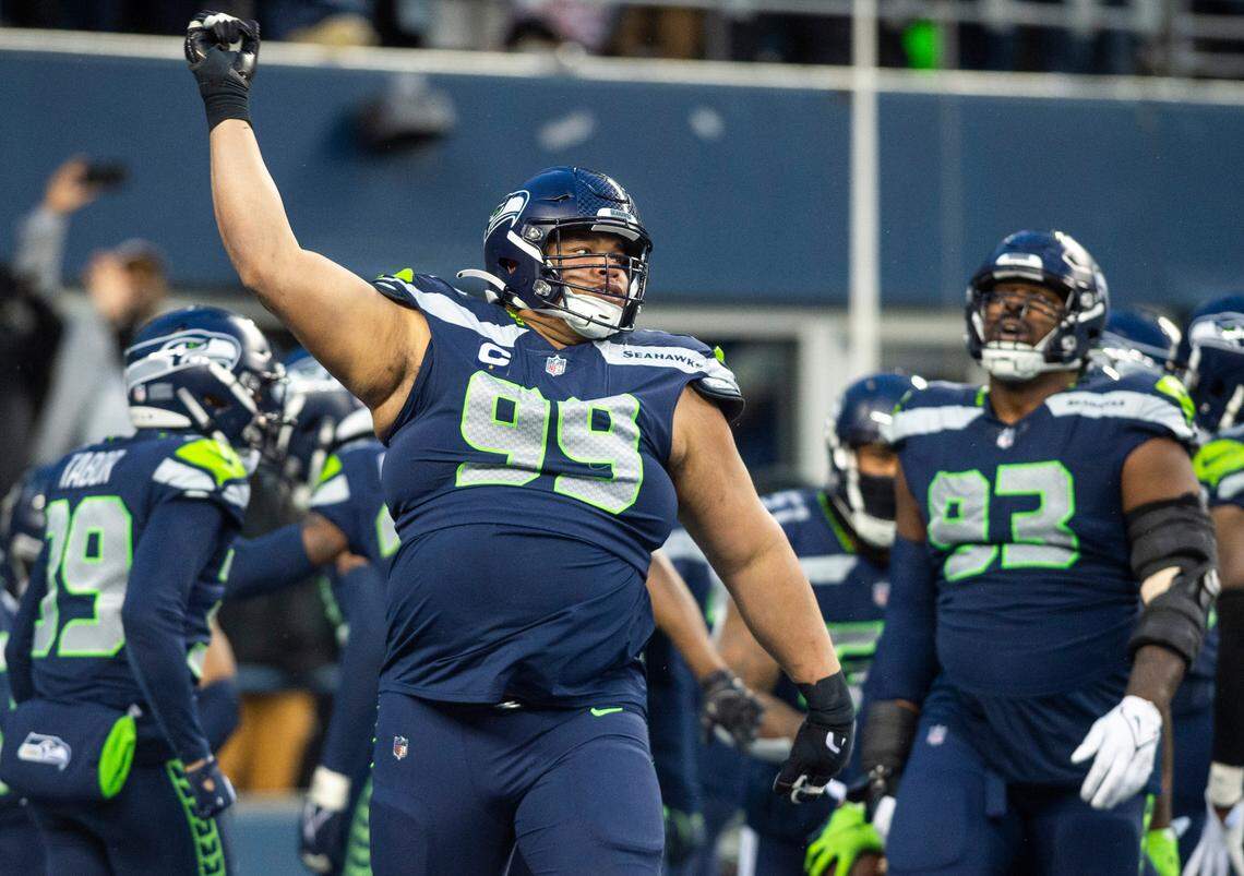 Seattle Seahawks defensive tackle Al Woods (99) celebrates after Seattle Seahawks safety Quandre Diggs (6) intercepted a pass in overtime of an NFL game against the Los Angeles Rams at Lumen Field in Seattle, Wash. on Jan. 8, 2023. The Seahawks defeated the Rams in overtime 19-16.