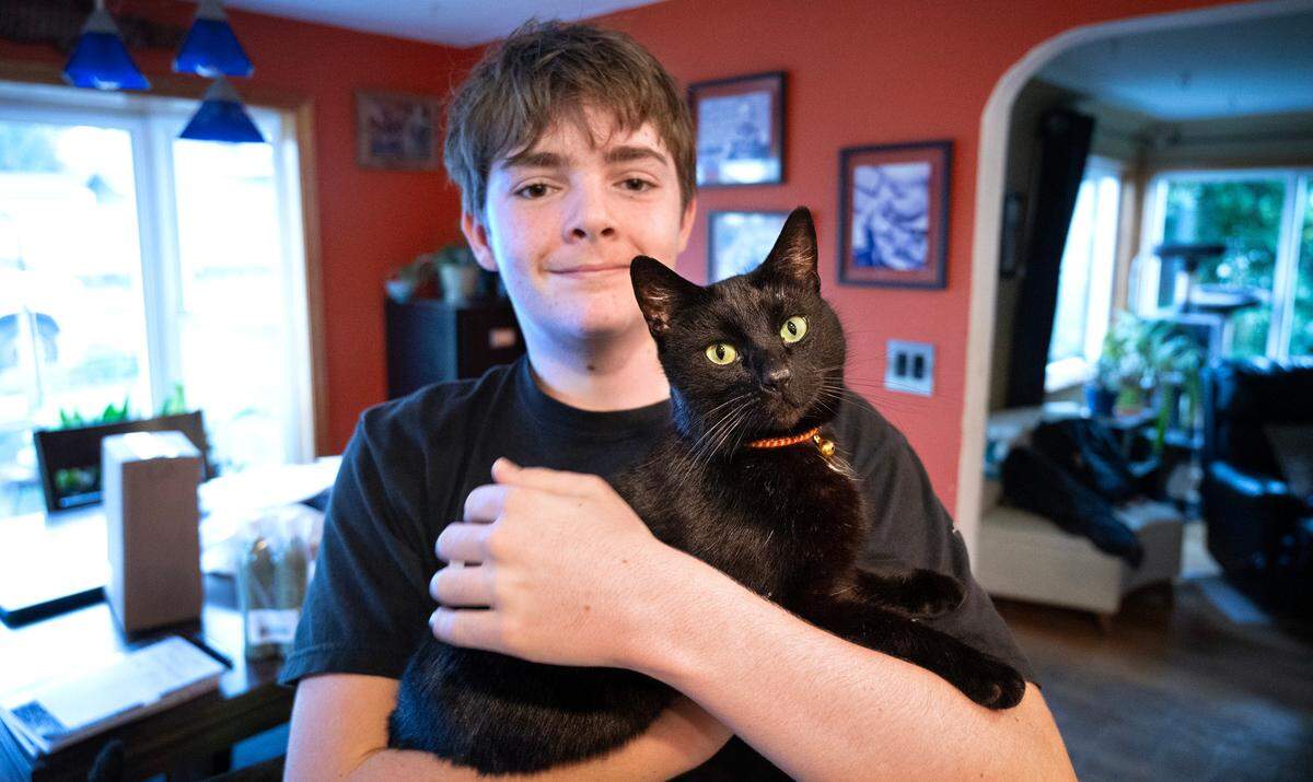 Remy Knoke was reunited with his long-lost cat, Coalie, who was found on the Key Peninsula after being gone for more than three years. The pair are shown at their home in Tacoma, Washington, on Tuesday, Feb. 20, 2024.
