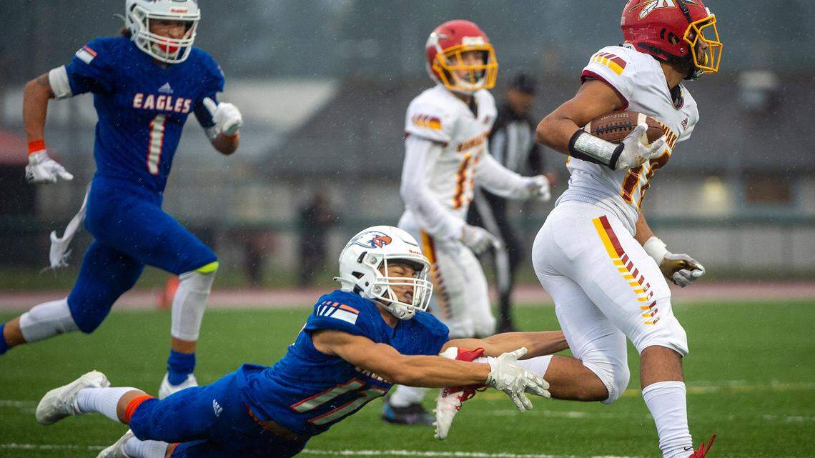 Graham Kapowsin’s Marques Naputi attempts to tackle Kamiakin’s Isaac Williams after he caught as pass from quarterback Henry Mercado during the third quarter of a State 4A semifinal game in Spanaway.