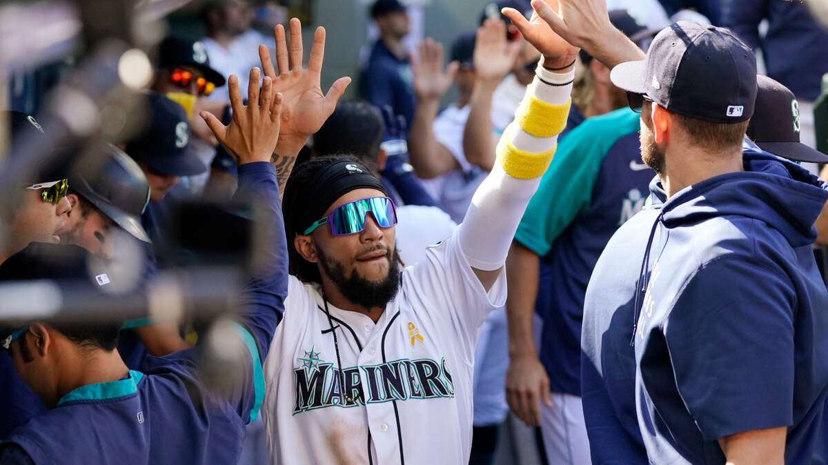 Seattle Mariners’ J.P. Crawford is congratulated by teammates after scoring against the Houston Astros during the sixth inning of a baseball game Wednesday, Sept. 1, 2021, in Seattle. (AP Photo/Elaine Thompson)