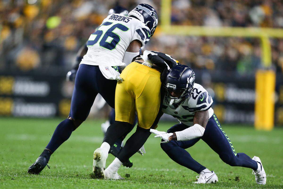 Seattle Seahawks cornerback Tre Brown (22) and Seattle Seahawks linebacker Jordyn Brooks (56) tackle Pittsburgh Steelers tight end Pat Freiermuth (88) during the first quarter. The Seattle Seahawks played the Pittsburgh Steelers at Heinz Field in Pittsburgh, Pa., on Sunday, Oct. 17, 2021.