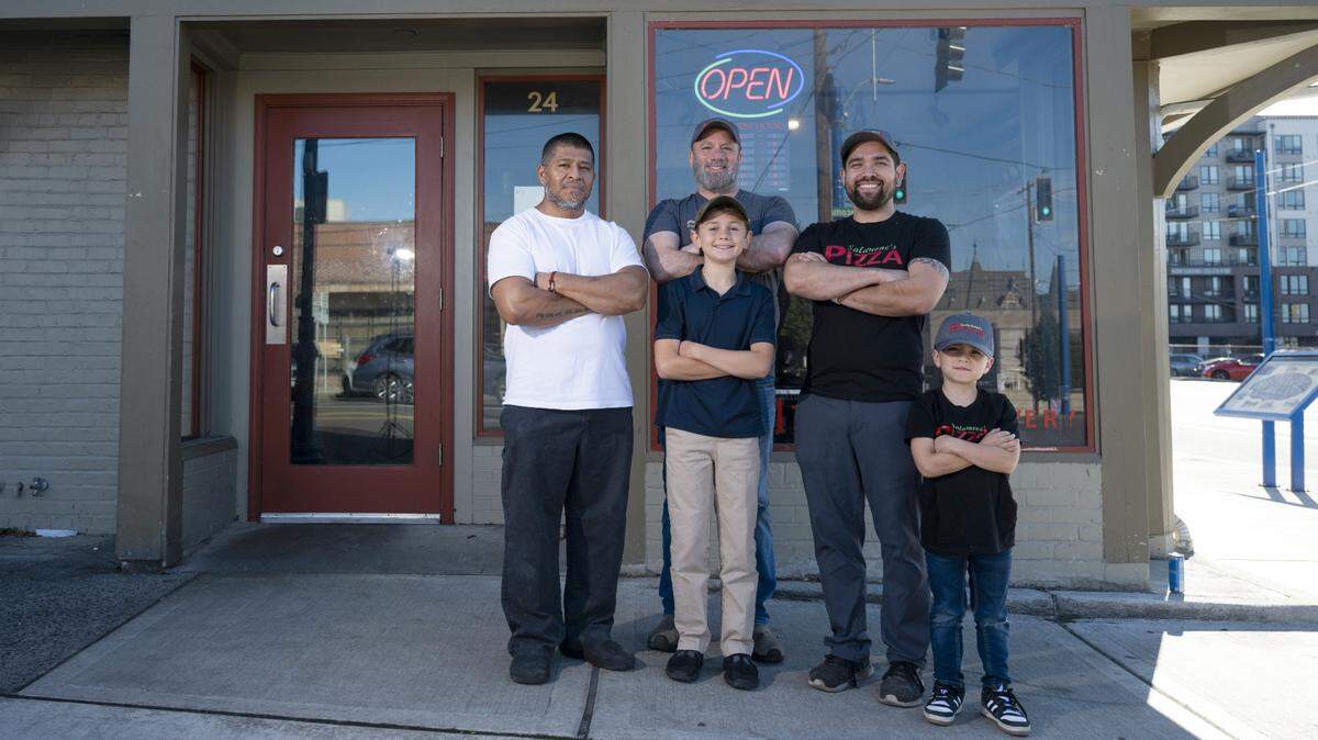 Ismael Monstesinos Gonzalez (left), Steve Salamone (center) with son Christopher, and Victor Mitchell with son Landon (right) photographed outside Salamone’s Pizza in Tacoma’s Stadium District on Wednesday.
