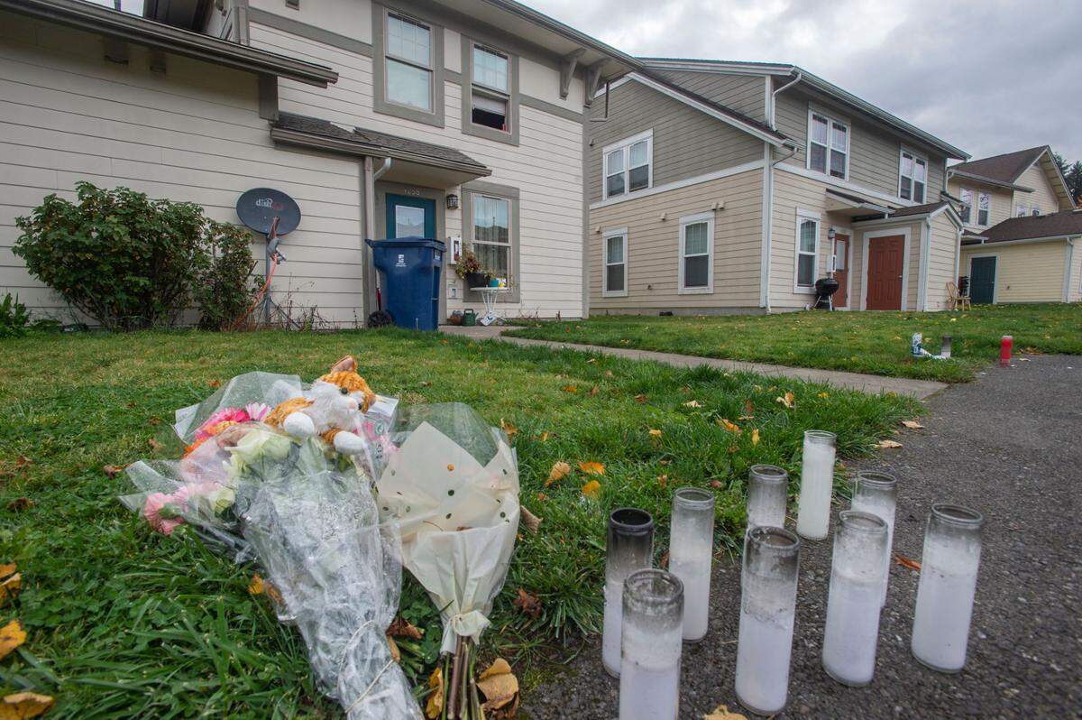 A memorial grows at the site where a mass shooting took the lives of four victims – Maria Nunez, Emery Iese, Raymond Williams and Natasha Brincefield – behind the home of a family matriarch in Tacoma’s Salishan neighborhood Thursday, Oct. 21, 2021.