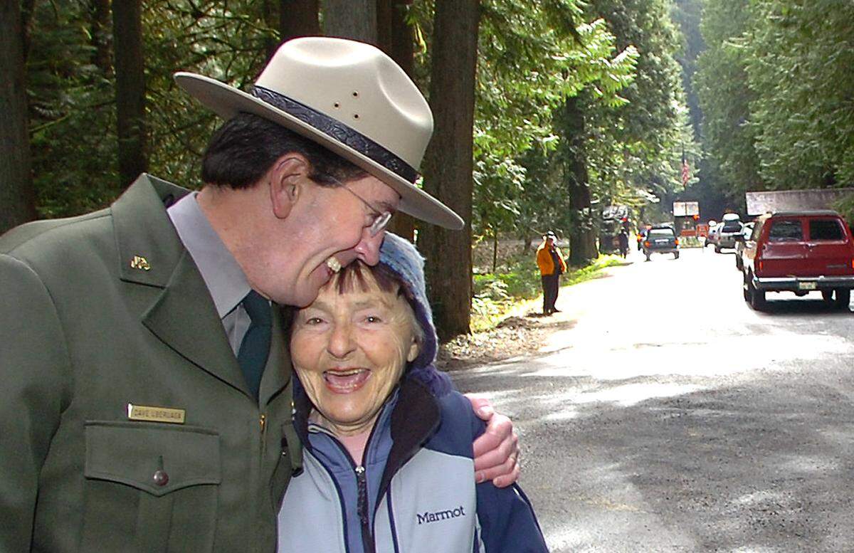 Mount Rainier National Park Superintendent David Uberuaga (left) gives a hug to local hiking legend Bronka Sundstrom at the main entrance to the Mount Rainier National Park in 2007. The two were at the ceremony for the reopening of the park after six a month closure from flood damage.