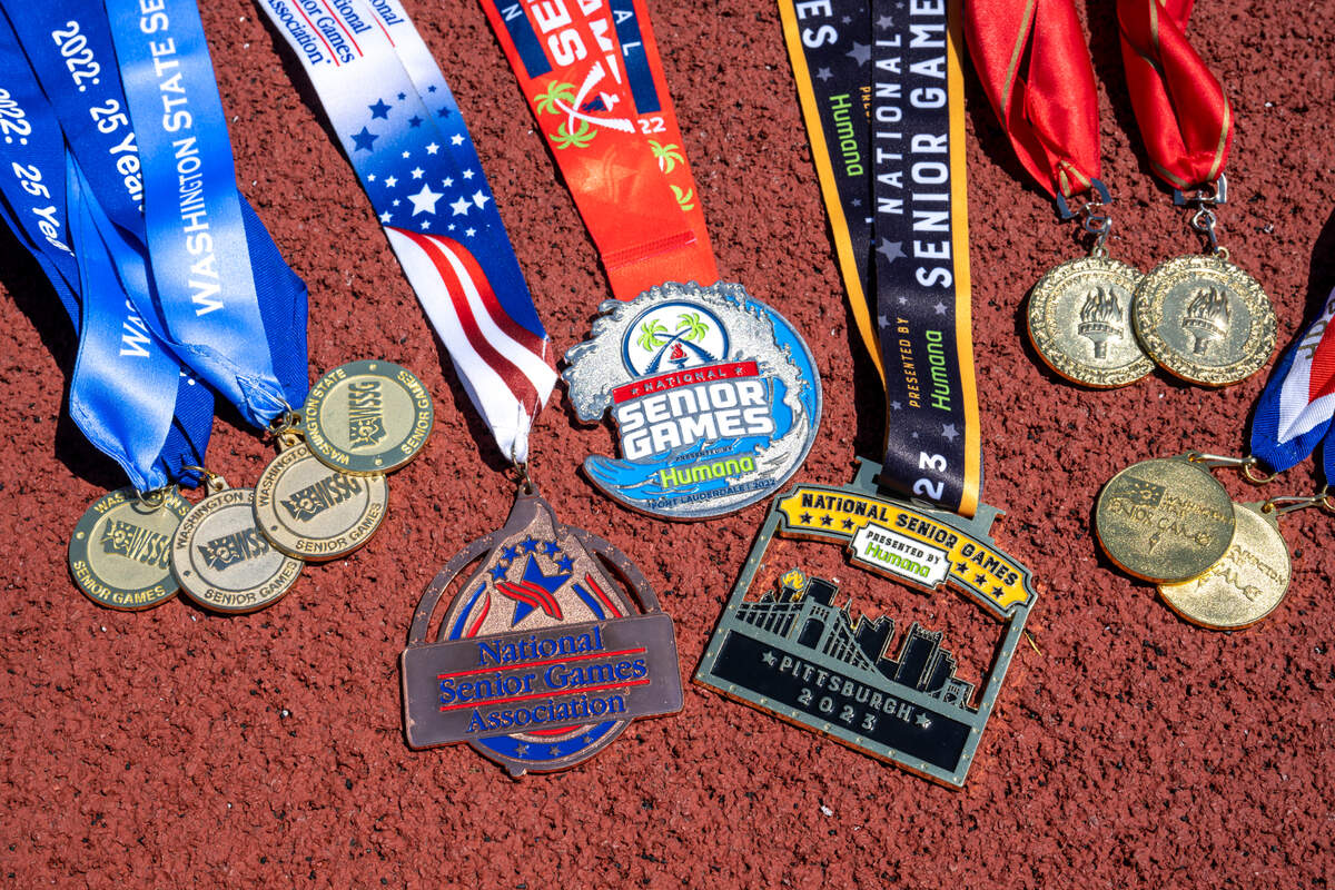 Medals from Madonna Hanna’s Washington State Senior Games and the National Senior Games are laid out on the track at Truman Middle School on Tuesday, July 8, 2025, in Tacoma.