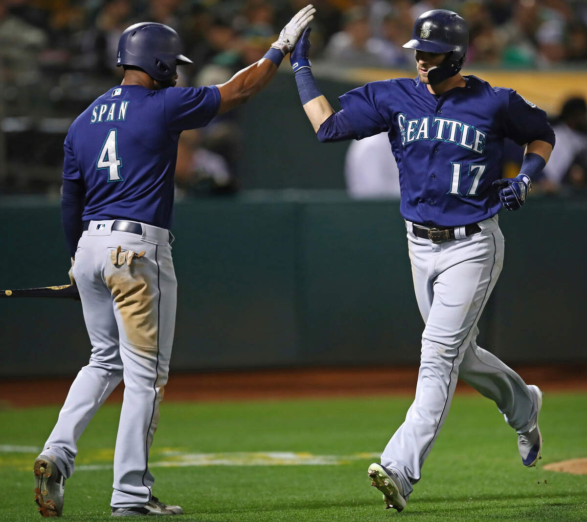 Seattle Mariners’ Mitch Haniger, right, is congratulated by Denard Span (4) after hitting a home run off Oakland Athletics’ Frankie Montas during the fourth inning of a baseball game Thursday, Aug. 30, 2018, in Oakland, Calif. (AP Photo/Ben Margot)