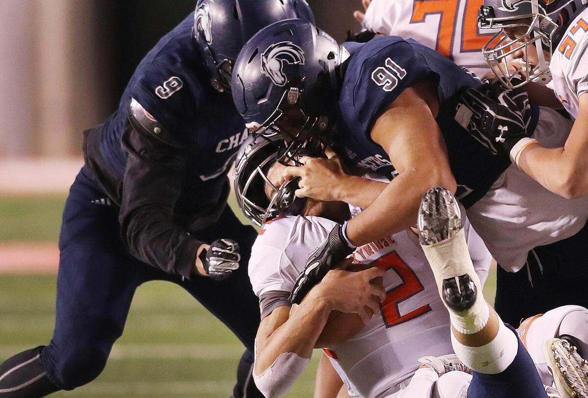 Skyridge High School quarterback Jayden Clemons is sacked roughly by Corner Canyon’s Van Fillinger during the 5A championship game in Salt Lake City on Friday, Nov. 16, 2018.