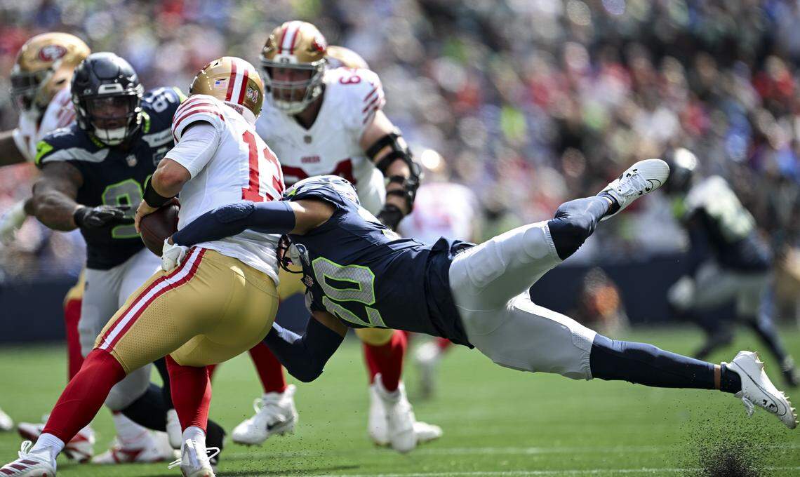Seattle Seahawks safety Julian Love (20) sacks San Francisco 49ers quarterback Brock Purdy (13) during the second quarter of the game at Lumen Field, on Sunday, Sept. 7, 2025, in Seattle.