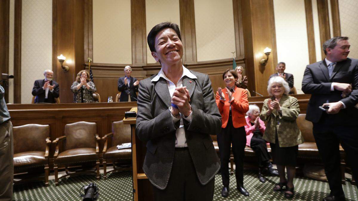 New Washington state Supreme Court Justice Mary Yu is applauded by current court members behind as she acknowledges the gallery after being sworn in to the bench Tuesday, May 20, 2014, in Olympia.