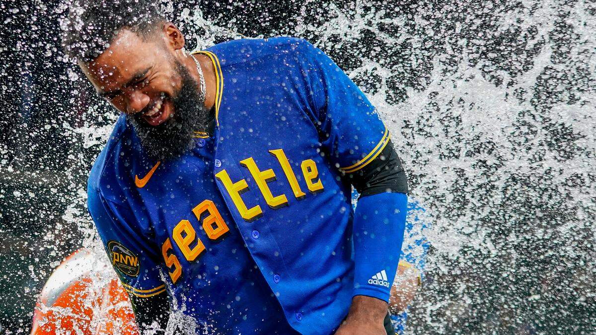 Seattle Mariners’ Teoscar Hernandez smiles as he is doused by teammate Julio Rodriguez after Hernandez hit a walk-off single for a 3-2 win over the Toronto Blue Jays in a baseball game, Friday, July 21, 2023, in Seattle. (AP Photo/Lindsey Wasson)