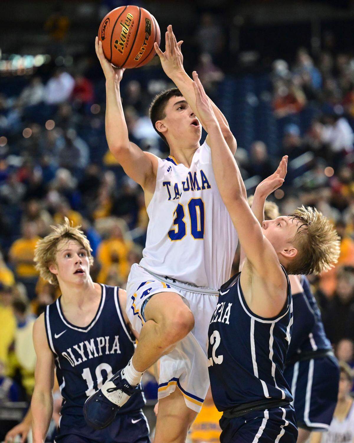 Tahoma forward Carson Talbert (30) attempts a shot as Olympia guard Parker Gerrits (22) defends during the fourth quarter of a Class 4A quarterfinal state tournament game on Thursday, March 3, 2022, at the Tacoma Dome, in Tacoma, Wash.