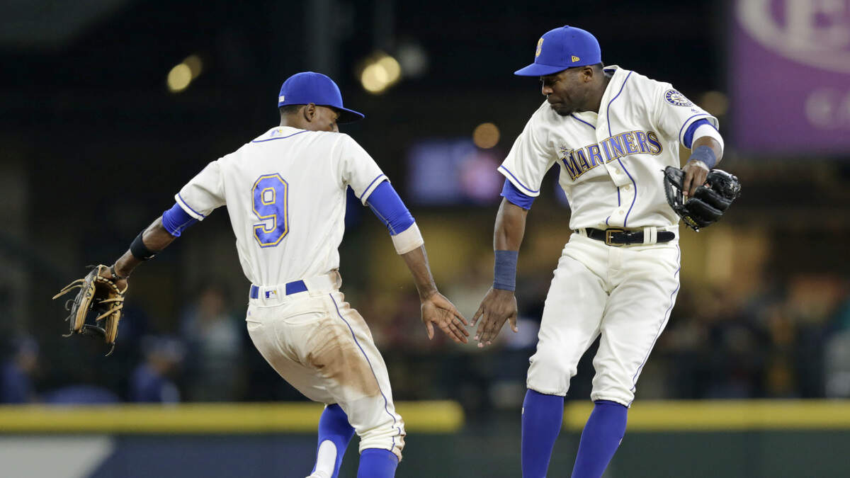Seattle Mariners' Dee Gordon, left, and Guillermo Heredia celebrate a win over the Tampa Bay Rays in a baseball game on Sunday, June 3, 2018, in Seattle. (AP Photo/John Froschauer)