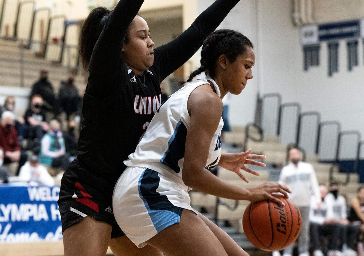 Olympia forward Natalia McBride (44) defends the ball from Union forward Eliana Fleming (22) during a West Central III/Southwest bi-district tournament girls basketball opening-round game on Friday, Feb. 11, 2022, at Olympia High School in Olympia, Wash.
