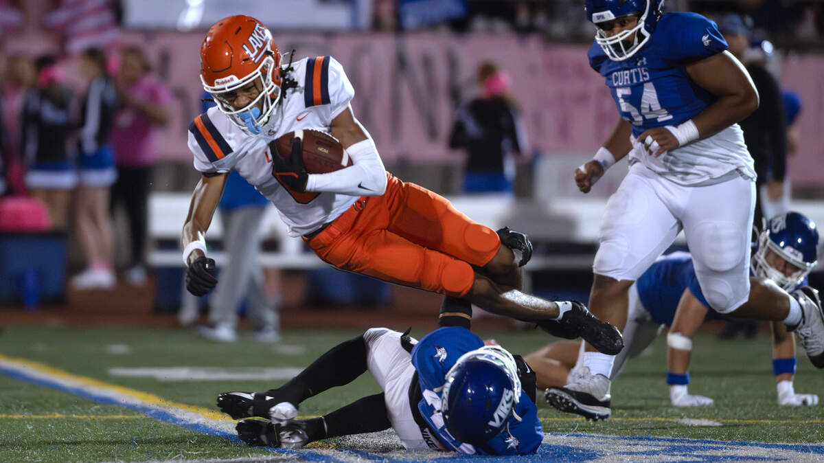 Lakes’ Bryce McCray leaps over Curtis’ Torry Thomas during Friday night’s football game at Viking Stadium in University Place, Washington, on Sept. 20, 2024. After trailing 10-0, Lakes won the game, 14-10.