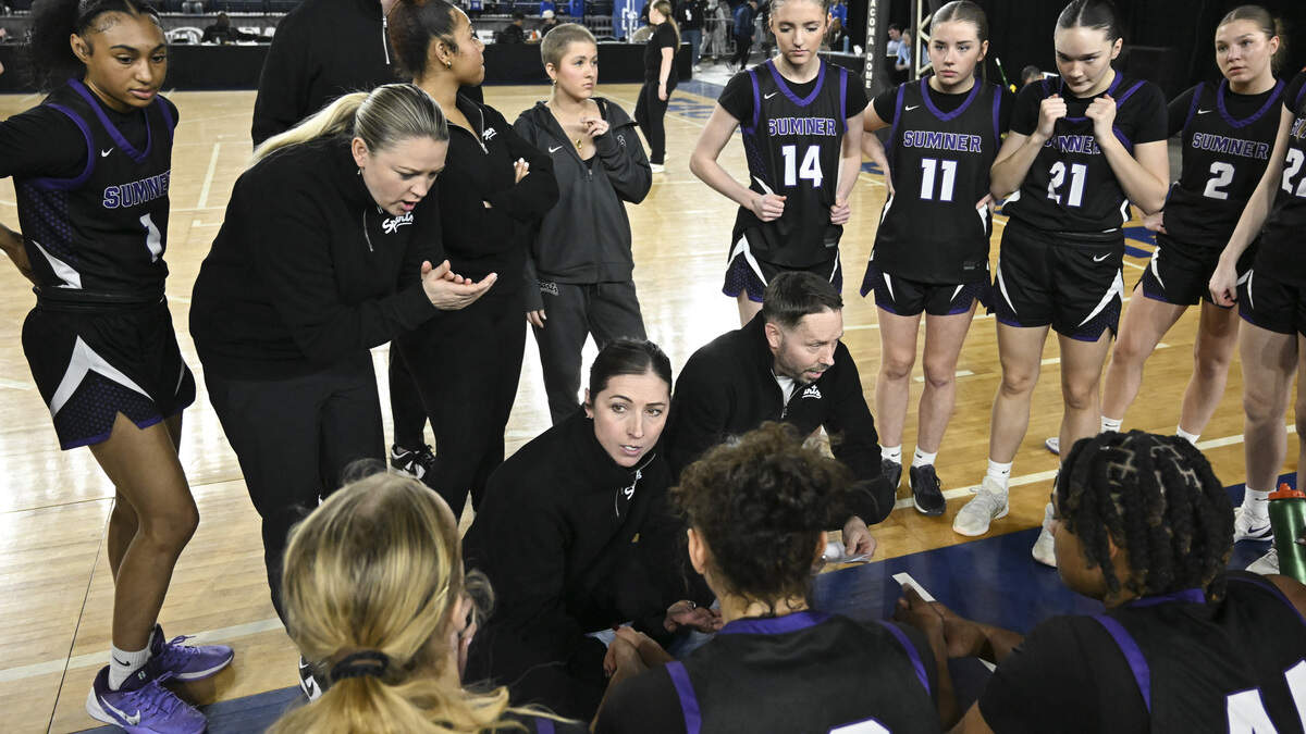 Sumner head coach Katie Hyppa, center, huddles up with players during the quarterfinal round of the 4A State Tournament against Union at the Tacoma Dome, on Thursday, March 5, 2026, in Tacoma, Wash.